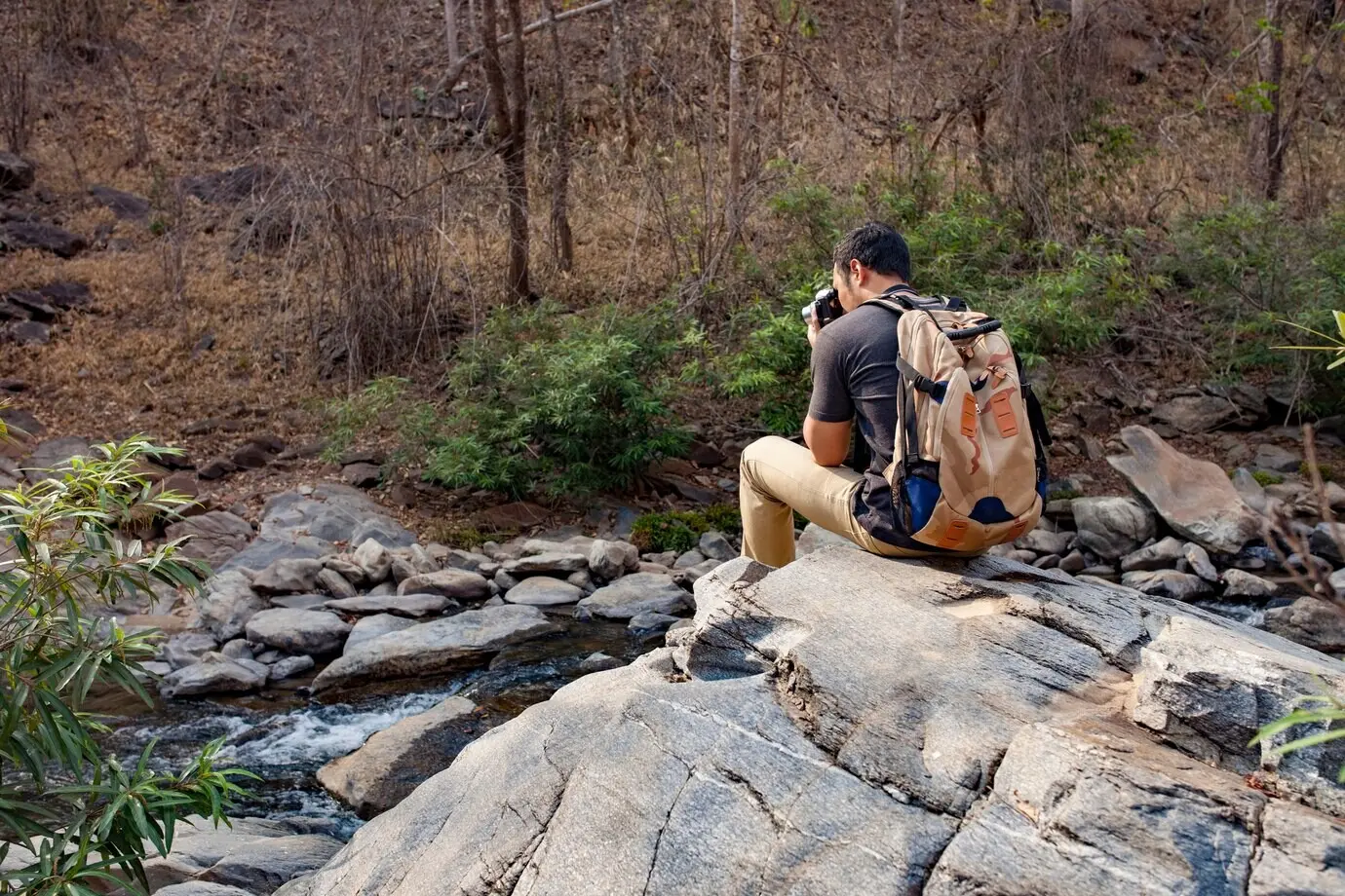 Wandernde Person auf einem Felsen, die ein Foto macht.